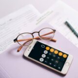 Close-up of a smartphone with calculator app showing Roth IRA conversion 2025 calculations