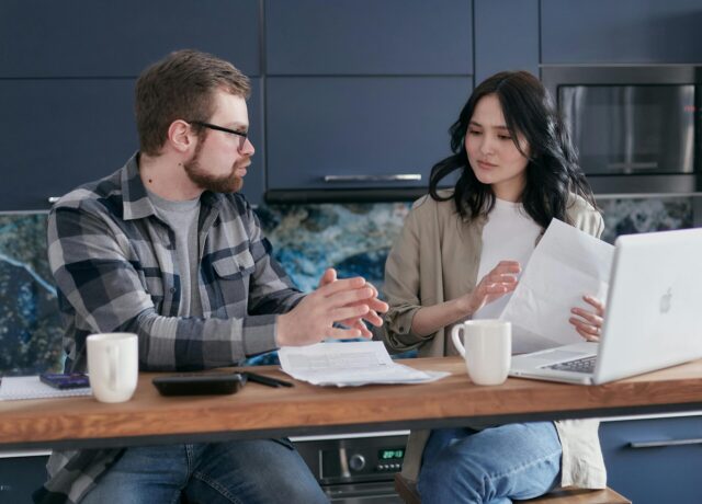 Person planning taxes with calculator, tax forms, and financial notes for 2026