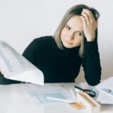 Person looking stressed while preparing taxes at home