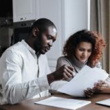 Family planning holiday budget together at a table with notebooks