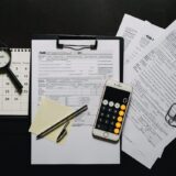Calculator and retirement planning documents showing 401k Roth catch-up requirement changes for 2026